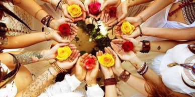 Circle of hands holding colorful roses.